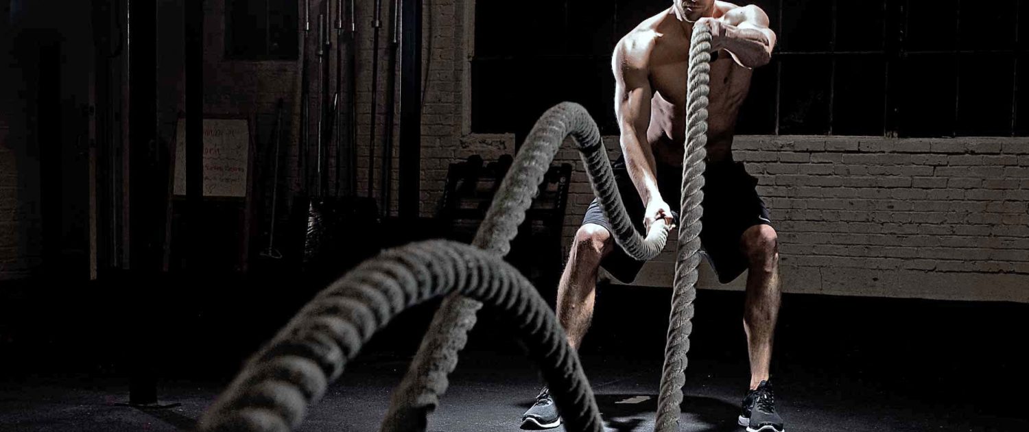 crossfit Uomo che si allena con battle rope